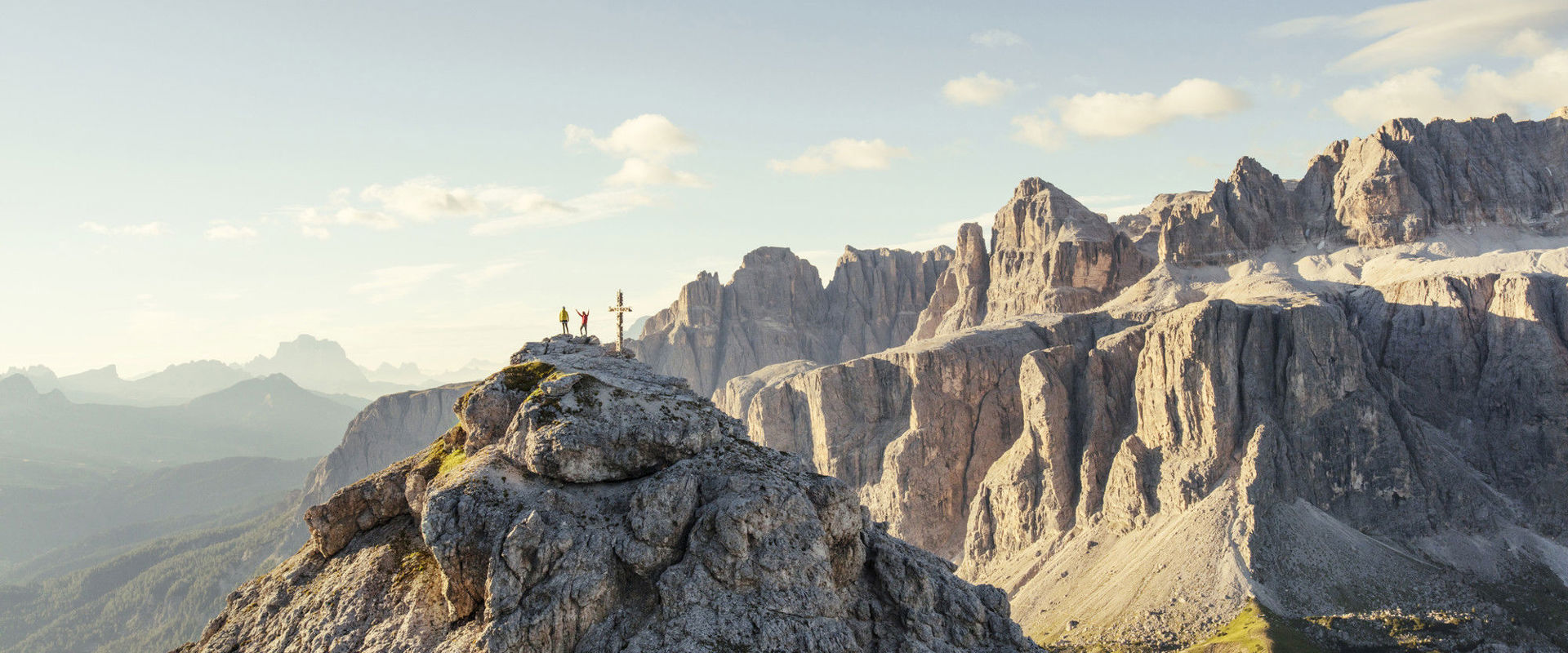 Wanderer beim Gipfelkreuz der Großen Cirspitze, mit Sellastock im Hintergrund