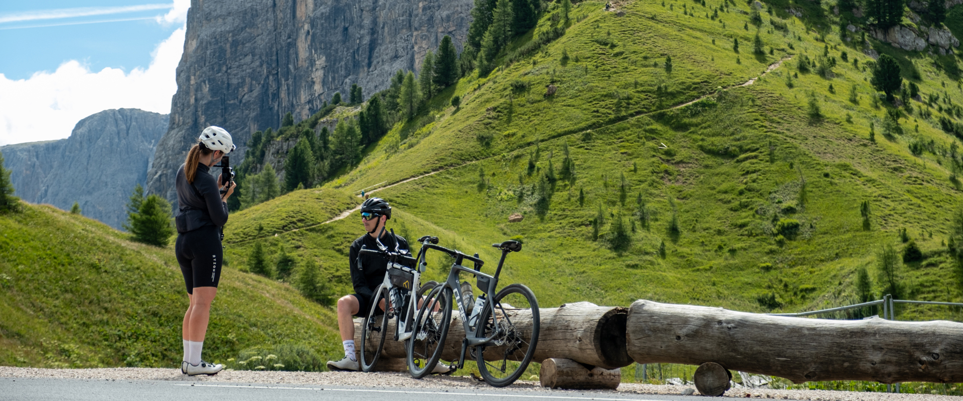 Rennrad in den Dolomiten Rennradfahrer bei der Rast auf Bergpassstraße in den Dolomiten