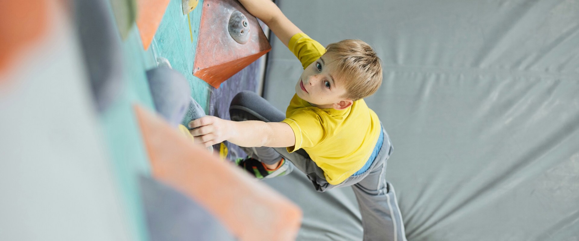 Kind an Kletterwand in Kletterhalle