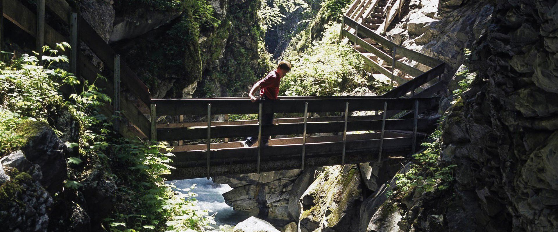 Gilfenklamm Mann geht auf einer Brücke über die Schlucht.