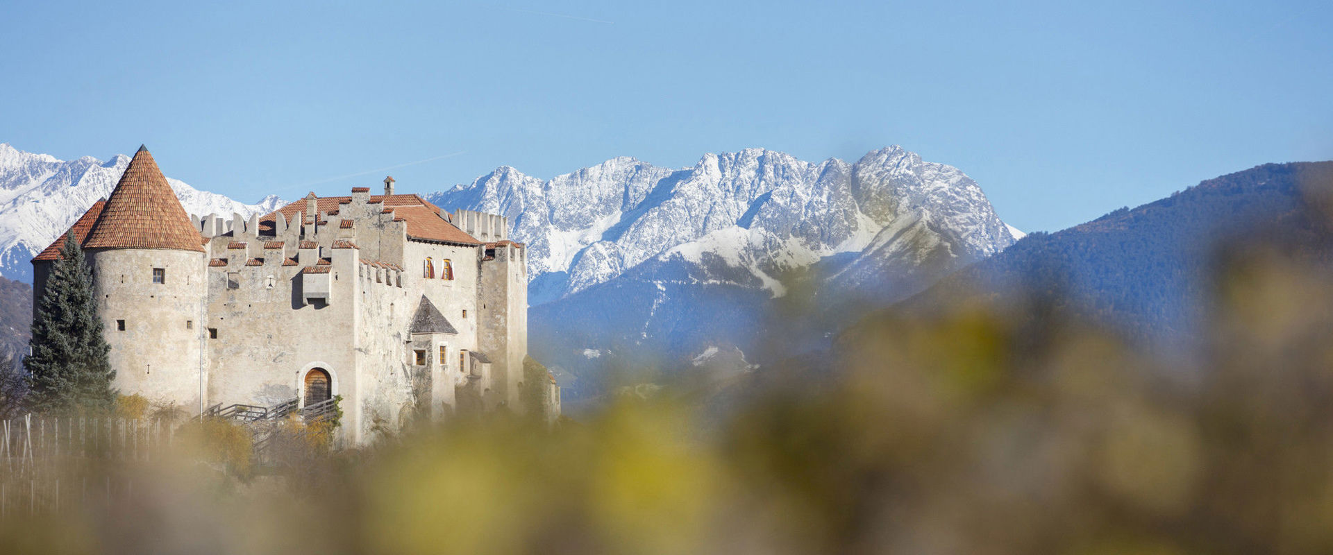 Schloss Kastelbell Schloss thront vor den imposanten Gipfeln der mit Schnee bedeckten Berge.