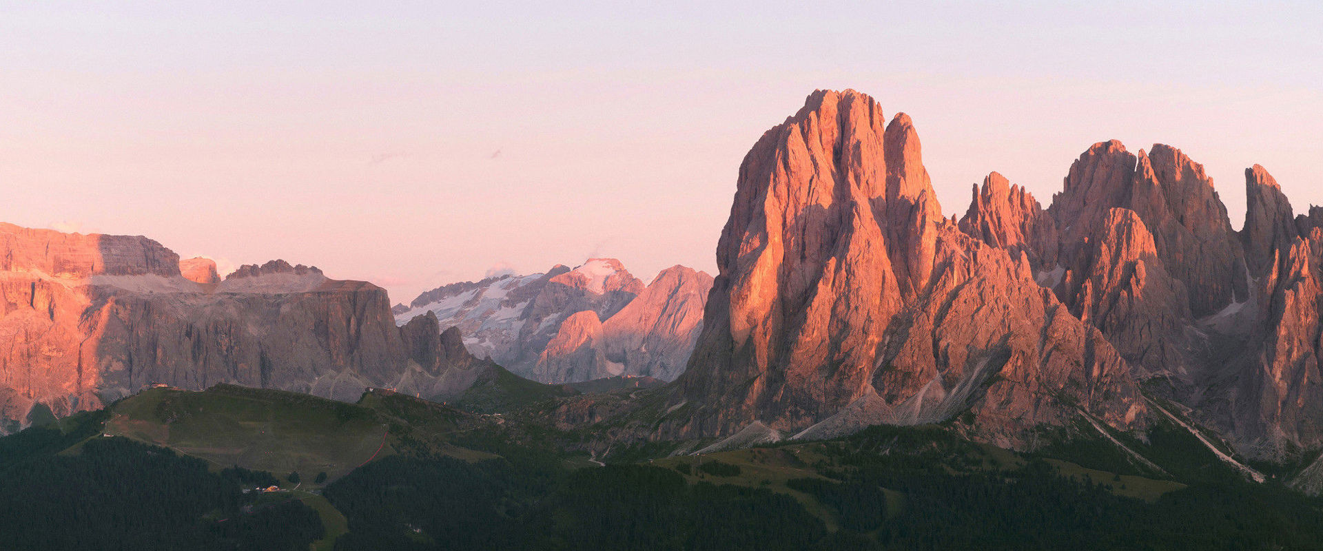 Alpenglühen. Die untergehende oder aufgehende Sonne färbt die Dolomiten rötlich bis violett.
